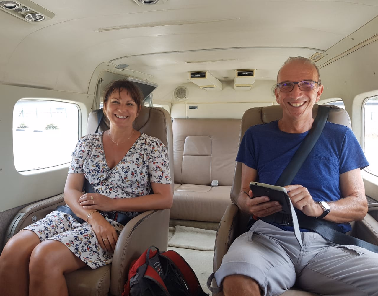 Smiling couple seated inside a Cinnamon air seaplane